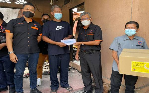 Nazri menerima sumbangan tunai daripada Zainuddin (dua dari kanan).