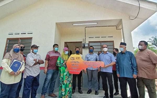 Zalinah (empat dari kiri) menerima replika kunci daripada Hee Sem ketika majlis penyerahan kunci di Kampung Tersusun Melaka Pindah pada Khamis.