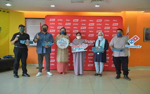Linda Hassan (empat dari kiri) menyerahkan Domino’s Pizza untuk disumbangkan kepada 500 pengunjung program Iftar Ala Madinah @Karangkraf pada Selasa. Sumbangan diserahkan kepada Ketua Pegawai Eksekutif Grup Buku Karangkraf, Firdaus Hussamuddin (dua dari kanan).