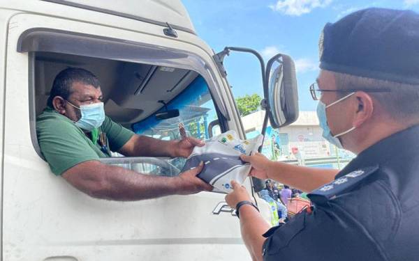 Ketua Polis Daerah Petaling Jaya Asisten Komisioner Mohamad Fakhrudin Abdul Hamid beramah mesra bersama pengguna jalan raya ketika Majlis Pelancaran Op Selamat di Plaza Tol PJS Lebuh Raya Pantai Baru di sini pada Khamis.