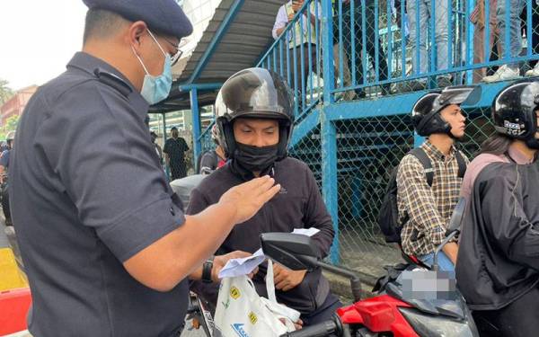 Mohamad Fakhrudin beramah mesra dengan pengguna jalan raya ketika Majlis Pelancaran Op Selamat di Plaza Tol PJS Lebuh Raya Pantai Baru pada Khamis.