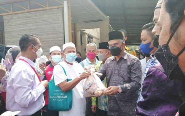 Daud (tiga dari kiri) menyampaikan ayam mentah kepada salah seorang penerima.