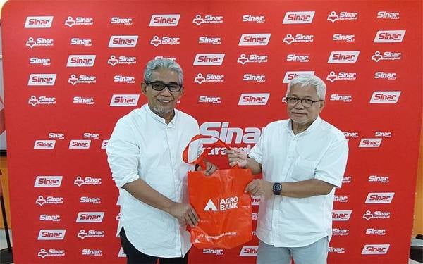 Tengku Ahmad Badli Shah (kiri) menyerahkan pek makanan sebagai simbolik kepada Hussamuddin (kanan) pada Khamis.