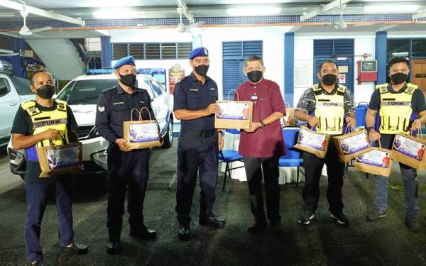 Salahuddin (tiga dari kanan) mengedarkan sumbangan makanan kepada anggota polis ketika Program Jelajah Singgah Sahur di pejabat Polis Marin di Tampoi, Johor Bahru pada Jumaat.
