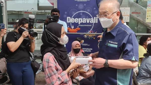 Ka Siong menagihkan pek hari raya kepada penumpang perkhidmatan KTMB.