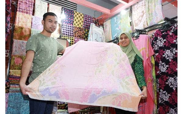 Suhaida menunjukkan batik buatan tangan yang dijual gerainya yang beroperasi di bangunan MARA Kuala Lumpur.