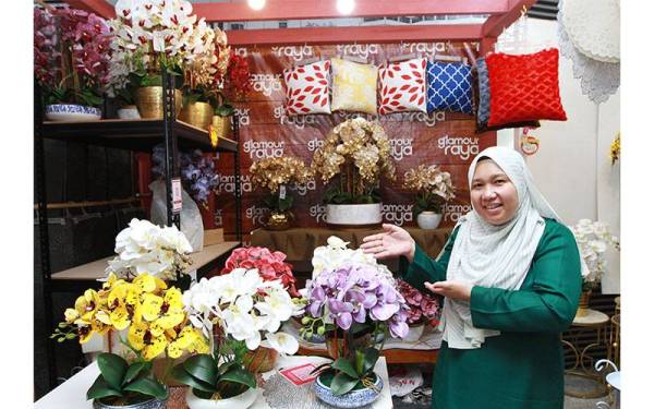 Norfatihah menunjukkan bunga hiasan yang dijual gerainya yang beroperasi di Bazar Glamour Raya Medan MARA.
