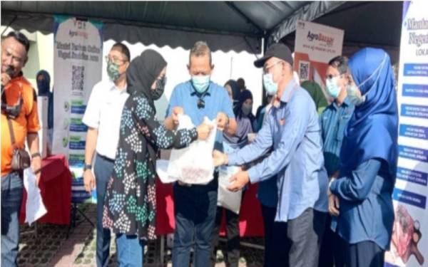 Aminuddin (empat dari kanan) ketika menyerahkan daging kepada pembeli daging secara dalam talian.