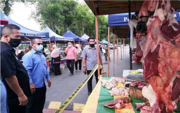 Azman (kiri) ketika meninjau oulet pemasaran di Pasar Tani Souq Al-Bukhary yang menawarkan harga berpatutan sempena program Semarak Syawal.