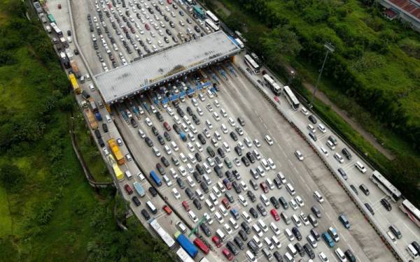 Kenderaan dari Jakarta menuju Jawa Barat bergerak perlahan sepanjang 2 KM di Jalan tol Trans-Jawa. Aliran trafik sesak di Gerbang Tol Cikampek Utama, Purwakarta, Jawa Barat berikutan orang ramai balik ke kampung untuk menyambut Hari Raya. - Foto Bernama
