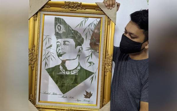 Muhammad Hafizi menunjukkan potret Pemangku Raja Pahang,Tengku Hassanal Ibrahim Alam Shah Al-Sultan Abdullah Ri'ayatuddin Al-Mustafa Billah Shah yang disiapkan selema tiga hari menggunakan 30 helai daun teja. - Foto: Bernama