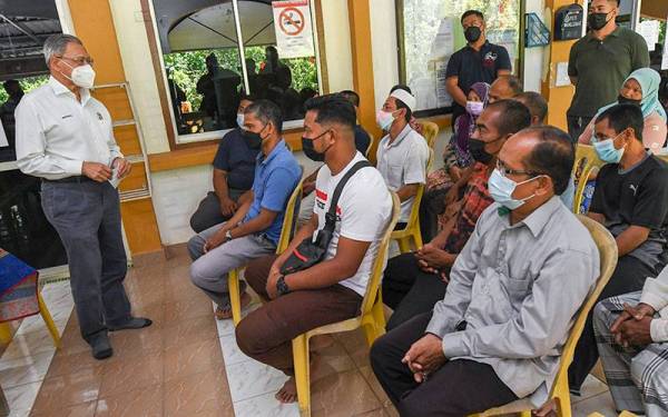 Mustapa (kiri) bertemu sebahagian penduduk pada Program Basmi Miskin Tegar Keluarga Malaysia (BMTKM) di Masjid Al Taqwa Mukim Jajawi pada Ahad. - Foto Bernama