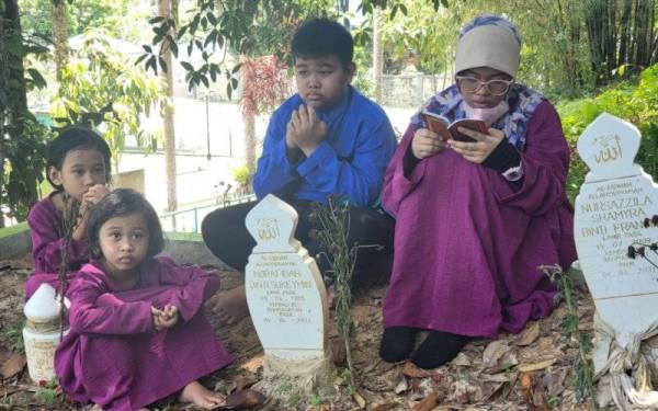 Nursazzey Shazmeka (kanan) bersama tiga adiknya Muhammad Irfan Ihtisyam (dua dari kanan), Nurmya Shaznira (kiri) dan Nurnafisya Shazniza (depan) menziarahi pusara kedua ibu bapa dan adiknya di Tanah Perkuburan Islam Kampung Ulu Putatan, Putatan.