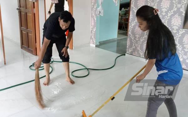 Kerja-kerja pembersihan rumah Saudah di Kampung Jasa Sepakat Pontian, dilakukan anak-anaknya yang pulang beraya selepas air mula surut pada pagi Khamis.