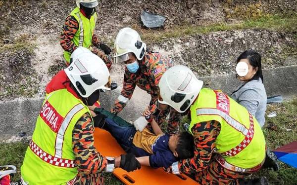 Anggota bomba membantu mengangkat mangsa yang terlibat dalam kemalangan tersebut. Foto Ihsan JBPM.
