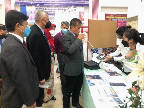 Dr Zaini (tiga dari kiri) mencuba alat mengesan penyakit asma ketika merasmikan Sambutan Hari Asma Sedunia 2022 dan Pelancaran Klinik Adma Teruk di Hospital Raja Perempuan Zainab II (HRPZ II) pada Ahad.