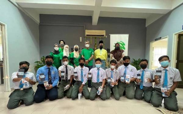 Pelajar daripada komuniti B40 bergambar bersama bantuan peralatan yang diberikan oleh Maxis.