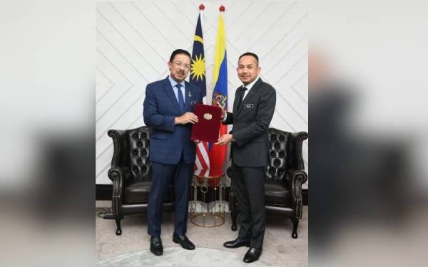 Mohd Zuki (kiri) menyampaikan watikah pelantikan kepada Sollehuddin.