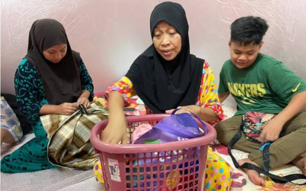 Marhumah (tengah) bersama anaknya ketika berada di PPS Dewan Selagon, Beaufort.