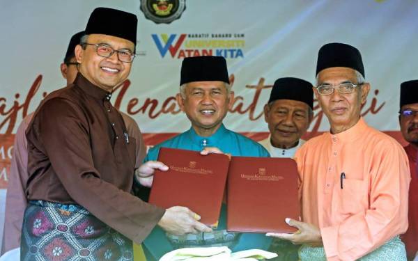 Muhammed (tengah) menyaksikan pertukaran dokumen antara Ketua Pegawai Eksekutif Yayasan Undang Johol Md Ghazali Md Yasin (kanan) dengan Mohd Ekhwan (kiri) sempena Majlis Menandatangani Memorandum Perjanjian Antara Universiti Kebangsaan Malaysia (UKM) dan Undang Luak Johol di Balai Undang Luak Johol, pada Selasa. Foto Bernama