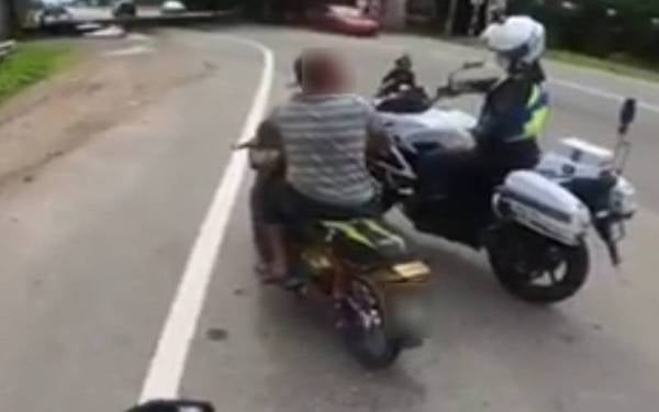 Seorang penunggang motosikal ditahan oleh UPB kerana tidak memakai topi keledar di sebuah lokasi di Kedah baru-baru ini. - Foto JPJ Kedah