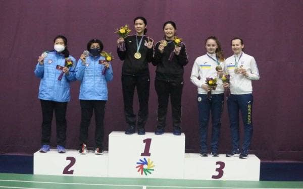 Pasangan beregu wanita pekak negara, Wei Ying- Zu Tung (tengah) bergambar bersama pingat emas yang dimenanginya pada temasya Deaflympic. - Foto MSDEAF