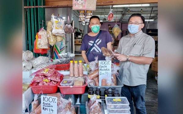 Tian Loo (dua dari kiri) ketika menyantuni peniaga di Jonker Walk di sini, pada Khamis.