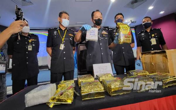 Jauteh (tengah) menunjukkan dadah jenis syabu yang dirampas pada sidang akhbar di IPK Kota Kinabalu.