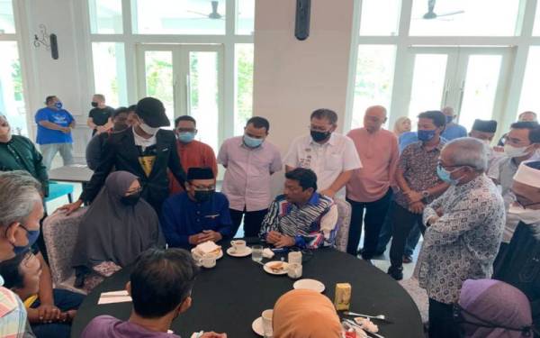 Syed Mohd Fazmi (duduk dari kanan) ketika menziarahi ahli keluarga dan waris mangsa di Hotel Casuarina Kuala Kangsar.