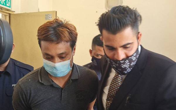 Muhammad Qayyum (kiri) dibawa ke Mahkamah Sesyen Petaling Jaya pada Jumaat bagi menghadapi pertuduhan kes merompak seorang penyampai berita minggu lalu.