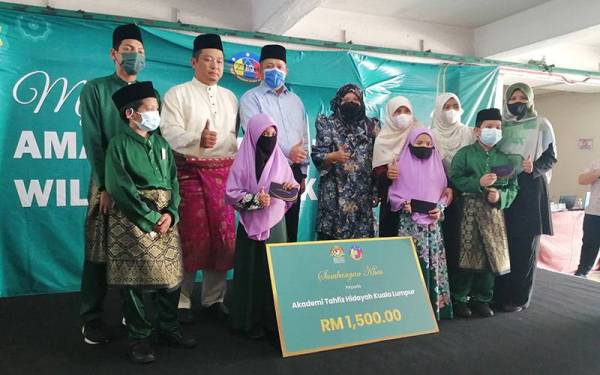 Shahidan (tiga dari kiri) bergambar bersama penghuni Akademi Tahfiz Hidayah yang menerima sumbangan Syawal daripada PPTGWP bersama Yayasan Wilayah Persekutuan.
