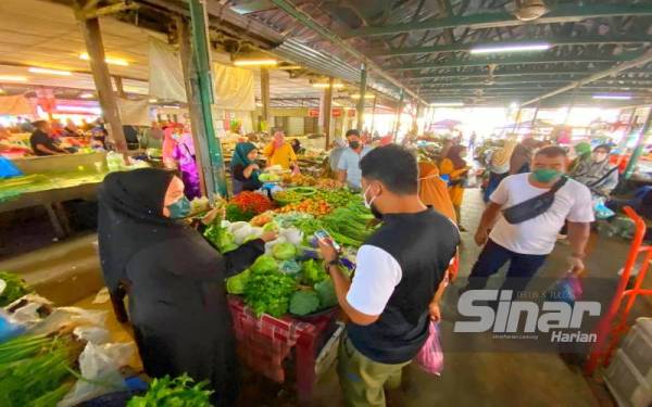 Siti Nurul Aida (kiri) tidak menang tangan melayan pelanggan di gerainya di Pasar Jelawat, Bachok.