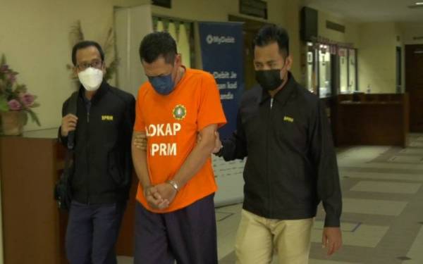 Suspek tiba di mahkamah pada jam 10.30 pagi berpakaian baju lokap dengan diiringi beberapa pegawai SPRM.