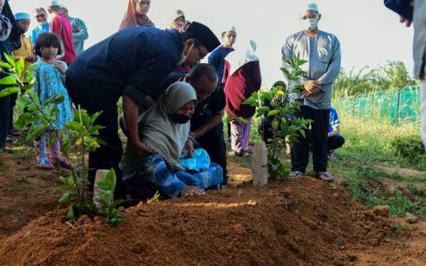 Ahli keluarga Allahyarham Iqbal Hasnun tidak dapat menahan sebak selepas jenazah pelajar Universiti Sultan Azlan Shah (USAS) itu dikebumikan di Tanah Perkuburan Kampung Melayu Seelong, Senai, pada pagi Sabtu. - Foto Bernama