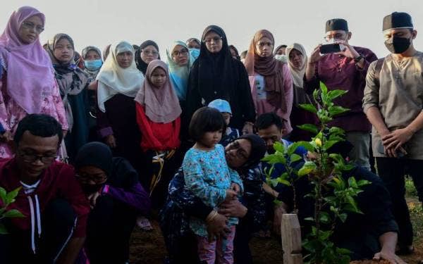 Antara ahli keluarga dan sahabat handai Allahyarham Iqbal Hasnun yang hadir ke pengebumian pelajar Universiti Sultan Azlan Shah (USAS) itu di Tanah Perkuburan Kampung Melayu Seelong, Senai, pada pagi Sabtu. - Foto Bernama