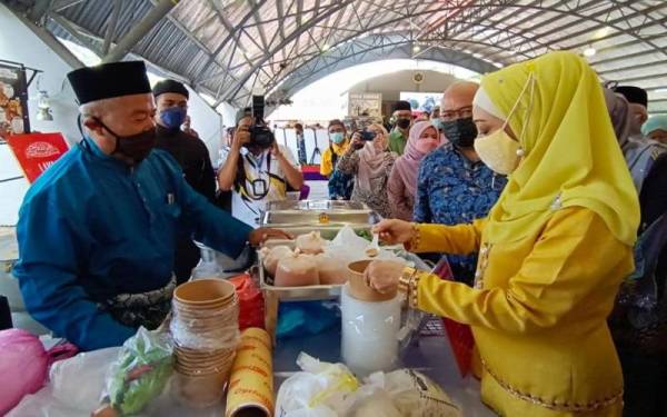Raja Nazhatul Shima melihat kepekatan kuah laksa yang disediakan di gerai Haji Arfan Nordin pada Temasya 99 Laksa Kuale di Kuala Kangsar pada Sabtu.