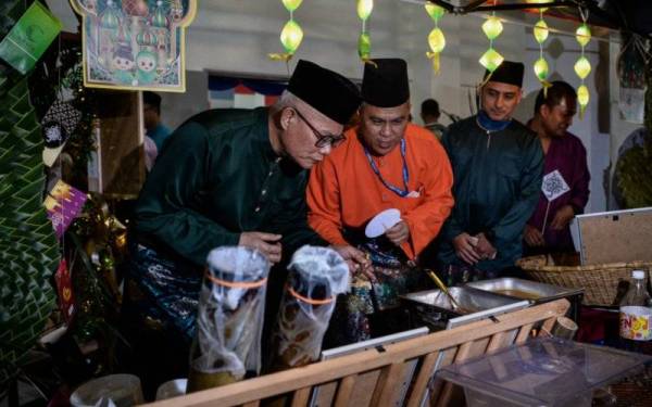 Mohammad Hamdan (kiri) melawat ke gerai makanan pada sambutan Hari Raya Aidilfitri, Hari Gawai dan Pesta Keamatan JBPM Kuala Lumpur di Dewan Serbaguna Kompleks Kuarters JBPM Cheras pada Isnin. 
