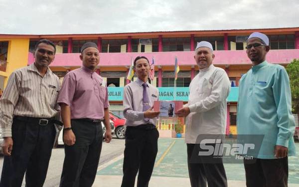 Abdul Aziz (kanan) mengiringi Razman (dua dari kanan) dalam Program Sumbangan Kek kepada sekolah-sekolah di sekitar DUN Semanggol pada Selasa.