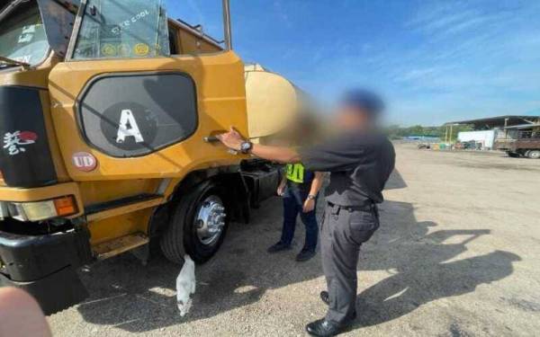 Anggota Batalion 5 PGA menunjukkan lori tangki yang disyaki terbabit dengan penyeludupan diesel bersubsidi di Jalan Sungai Tiram pada Selasa. - Foto PGA
