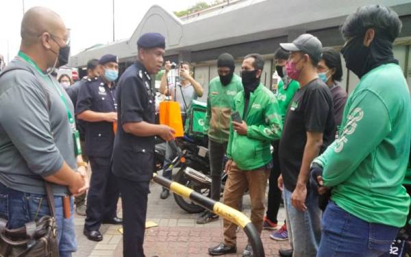 Wan Mohd Zahari mendekati sebahagian penghantar makanan ketika Kempen Pencegahan Jenayah dan Keselamatan Jalan Raya bersama Pemandu dan Penghantar Makanan E-hailing pada Rabu.