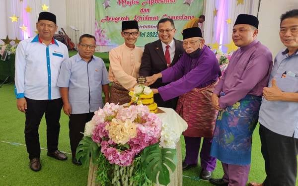 Mohamad Zahri (empat dari kanan) diiringi Azman (tiga dari kiri) memotong pulut kuning sebagai simbolik perasmian pada Majlis Apresiasi Kecemerlangan MDSB di Laman Mazmida Sungai Besar pada Khamis.