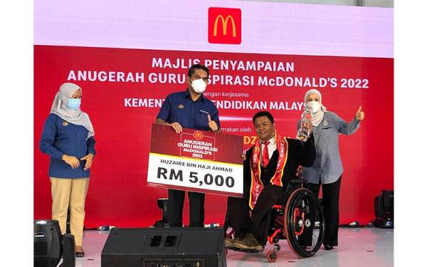 Mohd Radzi (dua dari kiri) menyampaikan Anugerah Guru Inspirasi McDonald’s 2022 kepada guru orang kurang upaya (OKU), Huzaire Ahmad (dua, dari kanan).