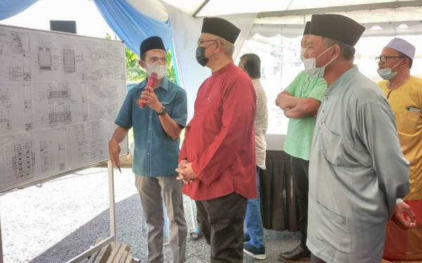 Jurutera ICU Selangor, Mohd Nazarudin Masnan (kiri) menerangkan tentang projek pembinaan surau baharu kepada Noh (dua dari kiri) pada Majlis Pecah Tanah Projek Meroboh dan Membina Baru Bangunan Surau Nurul Zaman Taman Seri Bakti, Tanjong Karang pada Jumaat.