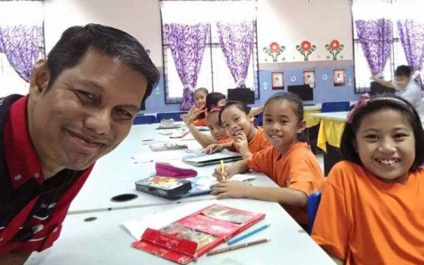 Faizal merakam gambar bersama murid-muridnya di SK Pulau Seduku Lingga, Sri Aman, Sarawak, ketika melakukan aktiviti di dalam kelas.