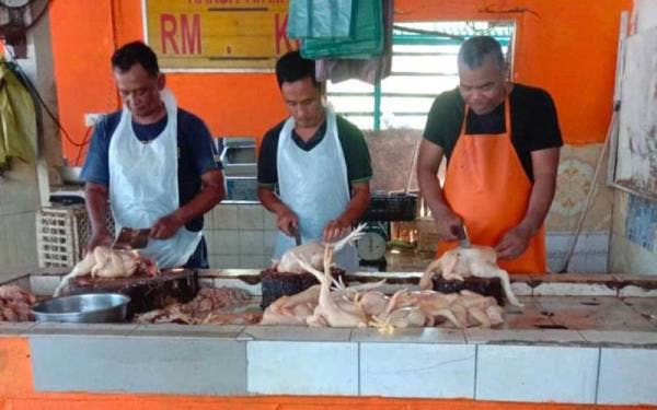 Peniaga memotong ayam untuk dijual kepada pelanggan di sekitar Badang, Kota Bharu.