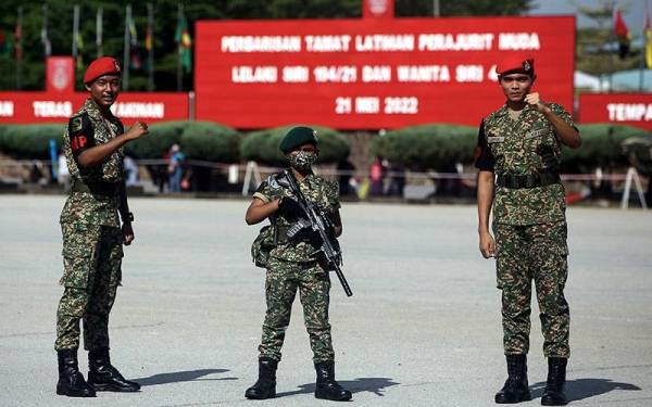 J Diveenesh, 9, (tengah) yang mengenakan pakaian lengkap Tentera Darat Diraja Malaysia (TDM) bergambar bersama anggota TDM pada acara Perbarisan Tamat Perajurit Muda Lelaki Siri 194/21 dan Wanita Siri 47/21 di Pusat Latihan Asas Tentera Darat (PUSASDA) hari ini.