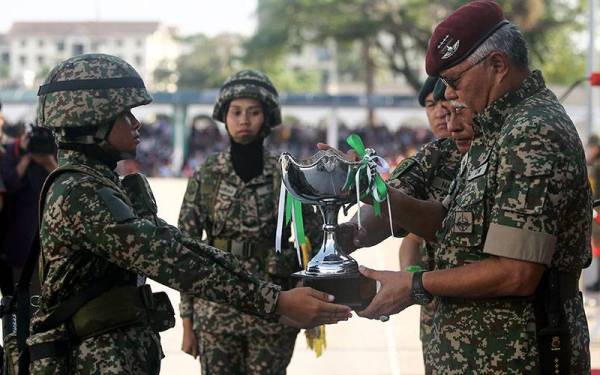 Panglima Tentera Darat (PTD) Jen Tan Sri Zamrose Mohd Zain (kanan) menyampaikan piala kepada perajurit muda Wanita Terbaik Nur Syafiqah Liyana Mohd Noor pada Perbarisan Tamat Perajurit Muda Lelaki Siri 194/21 dan Wanita Siri 47/21 di Pusat Latihan Asas Tentera Darat (PUSASDA) hari ini.