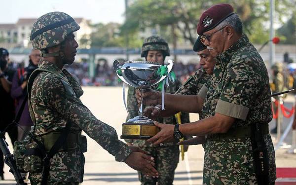 Panglima Tentera Darat (PTD) Jen Tan Sri Zamrose Mohd Zain (kanan) menyampaikan piala kepada perajurit muda Keseluruhan Terbaik Mohamad Nor Farhan Mahzal pada acara Perbarisan Tamat Perajurit Muda Lelaki Siri 194/21 dan Wanita Siri 47/21 di Pusat Latihan Asas Tentera Darat (PUSASDA) hari ini.