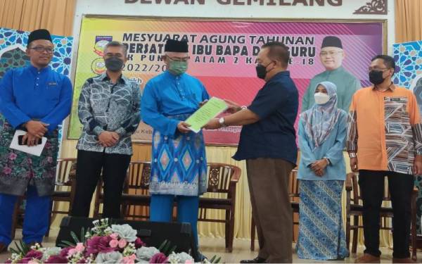 Pengerusi Majlis Guru Besar Daerah Kuala Selangor, Ahmad Daud Ab Hamid (tiga dari kanan) menyerahkan surat penghargaan sumbangan kepada Noh (tiga dari kiri) pada Majlis Perasmian Mesyuarat Agung PIBG SK Puncak Alam 2, pada Sabtu.