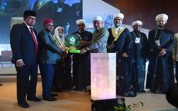 Idris Ahmad (empat dari kanan) menyerahkan logo persidangan kepada Mohd Khairuddin (dua dari kiri) simbolik penutupan Sidang Kemuncak Ulama 2022 Perpaduan Asas Pembebasan Al-Aqsa hari ini. Foto Bernama